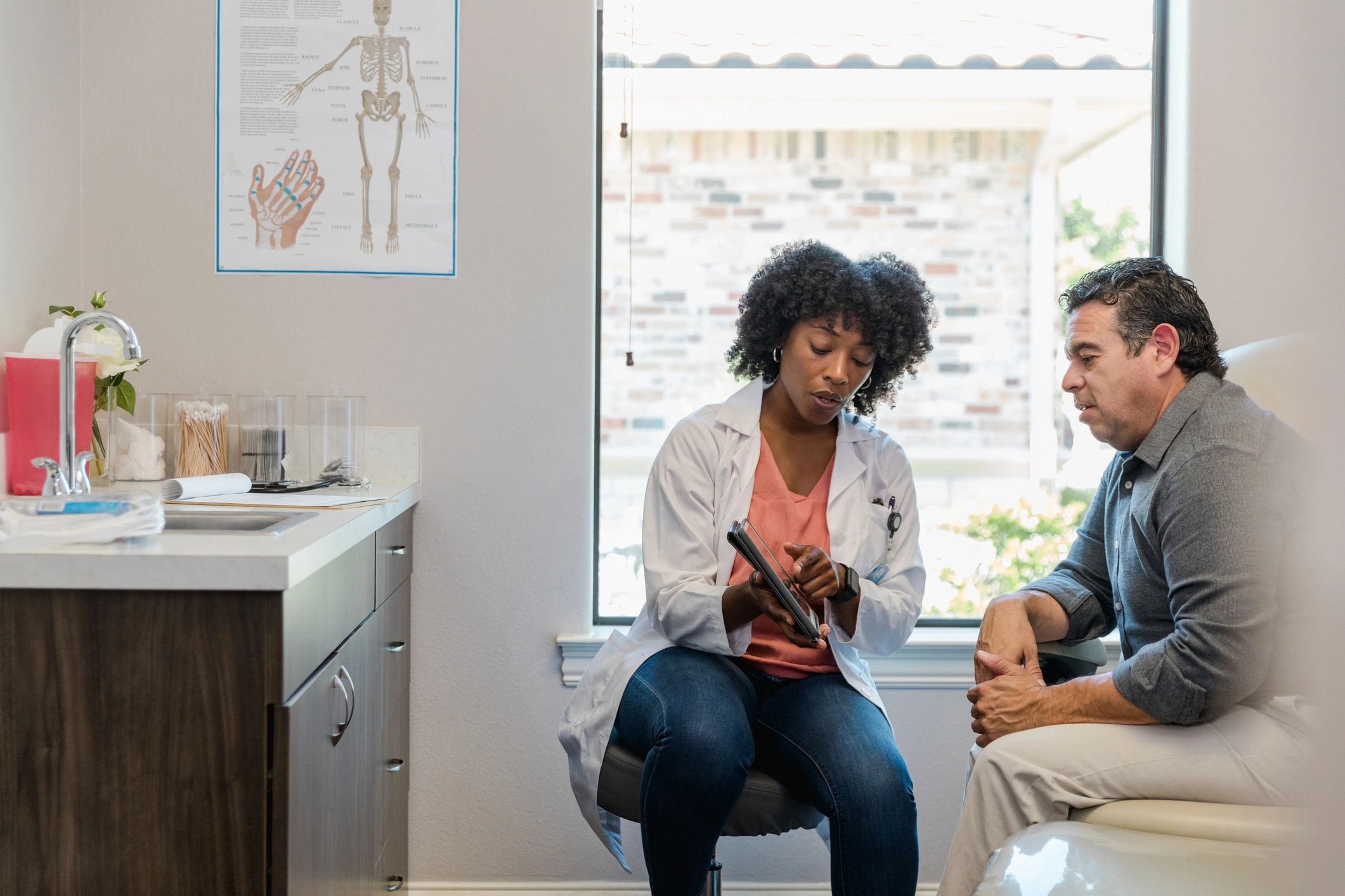 Doctor discussing information with a patient using a tablet