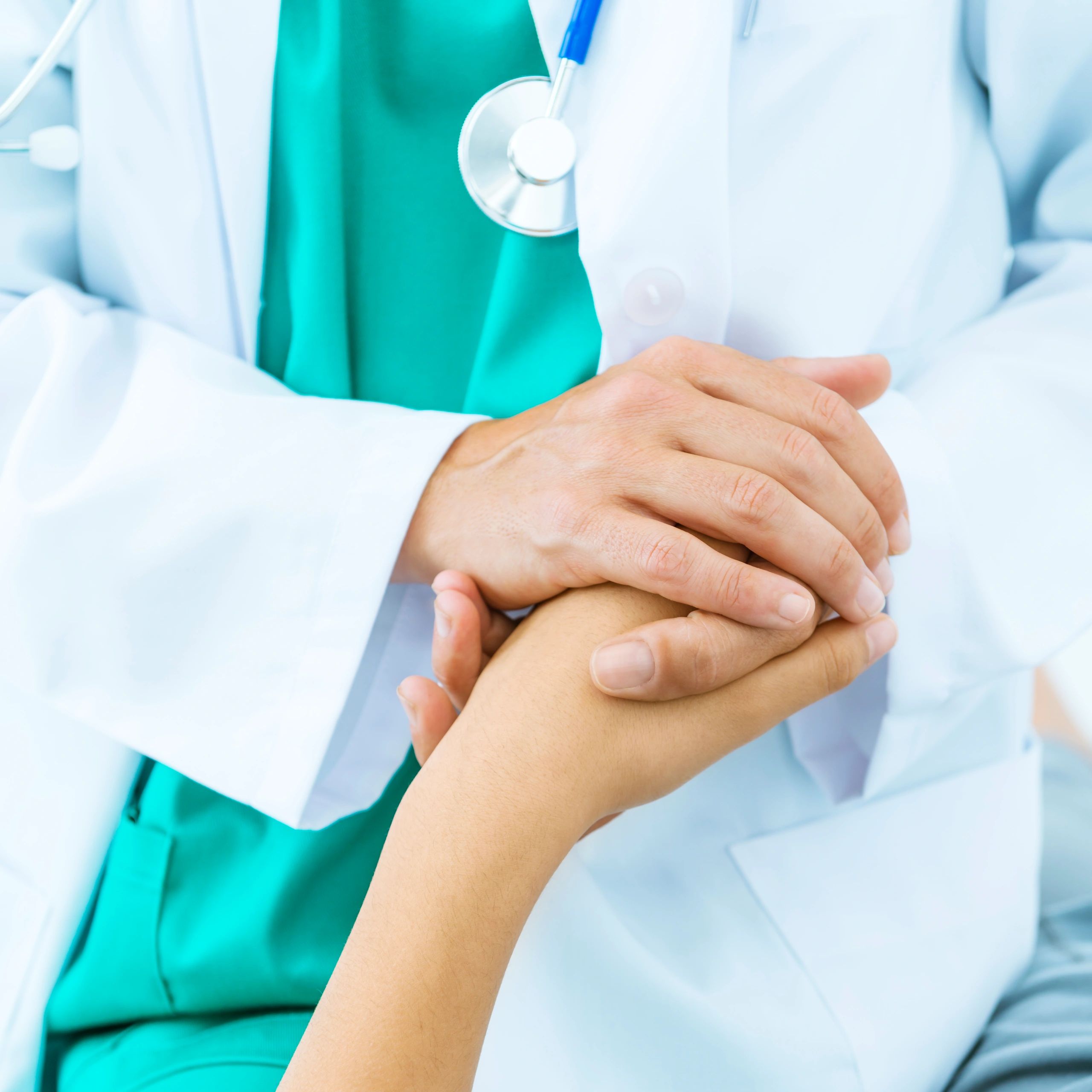 Doctor holding a patient's hand in a supportive gesture