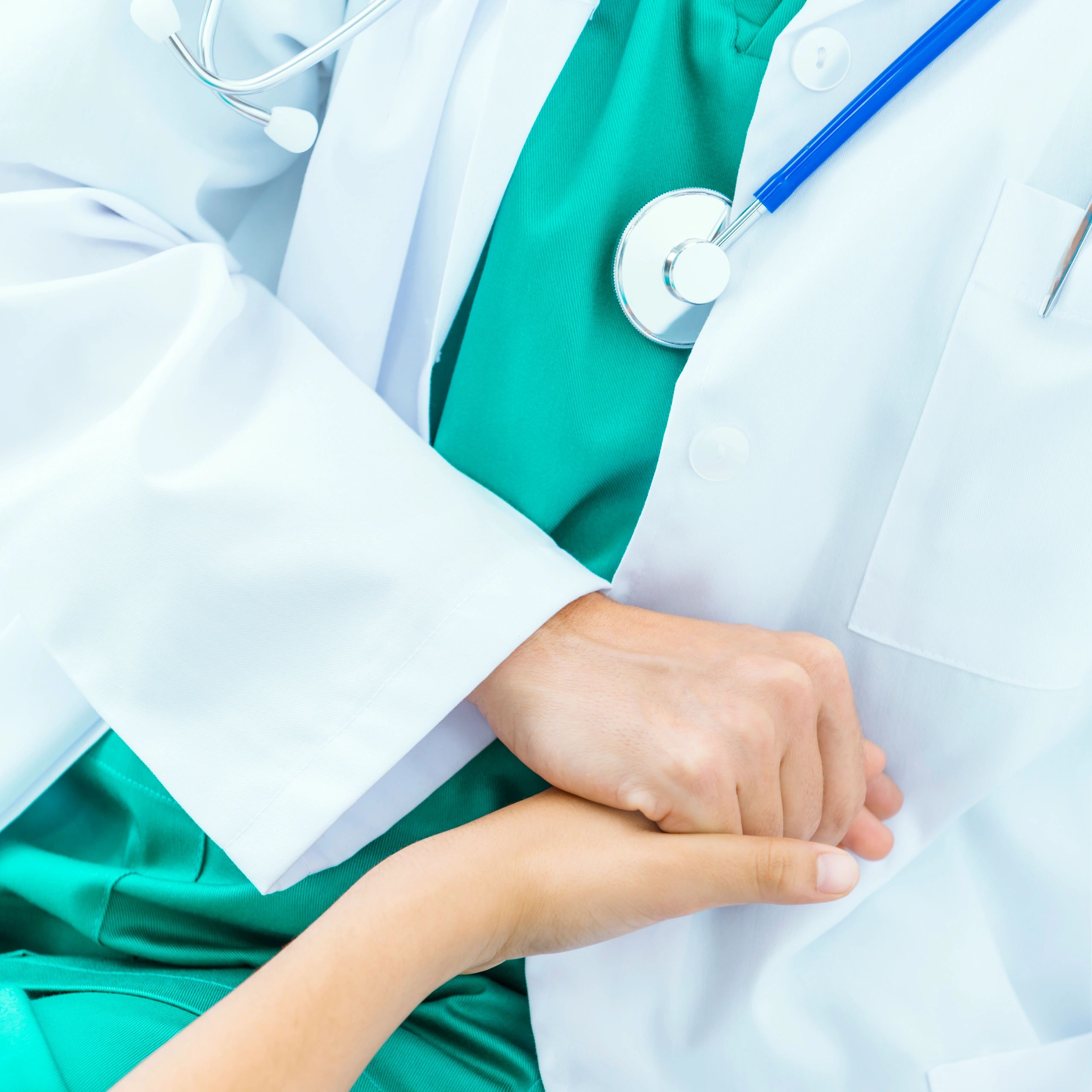 Doctor holding a child patient's hand