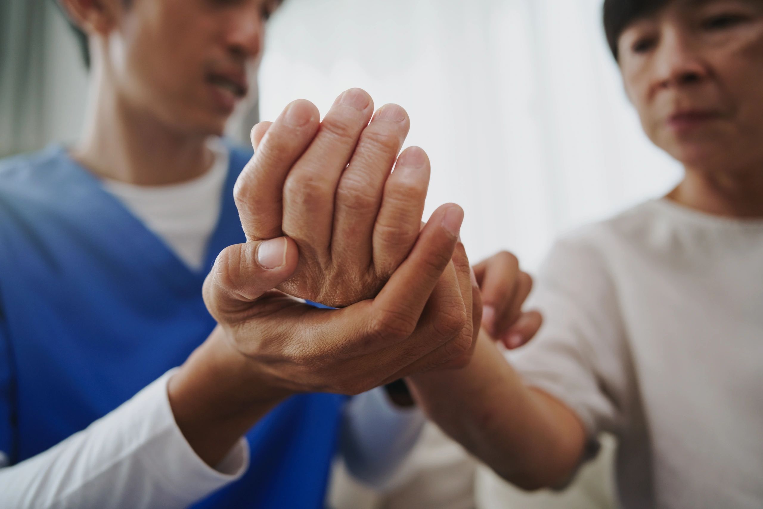 Clinician holding a patient’s hand in a supportive gesture